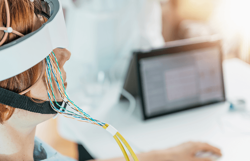 Hände einer Fachperson befestigen Elektroden an einer Kappe mit vielen Sensoren auf dem Kopf einer Person für eine Neurofeedback-Messung